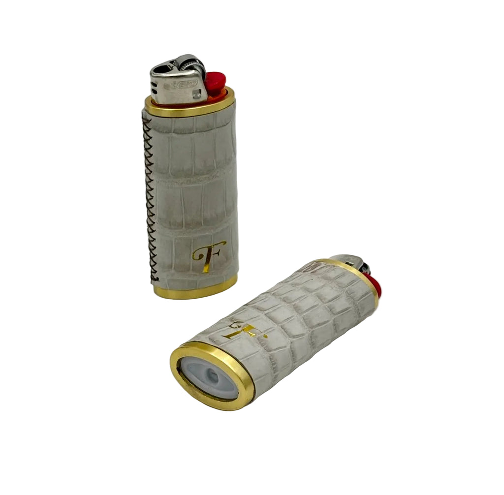 Two Himalayan alligator leather lighter sleeves with gold hardware rings showing front and back views