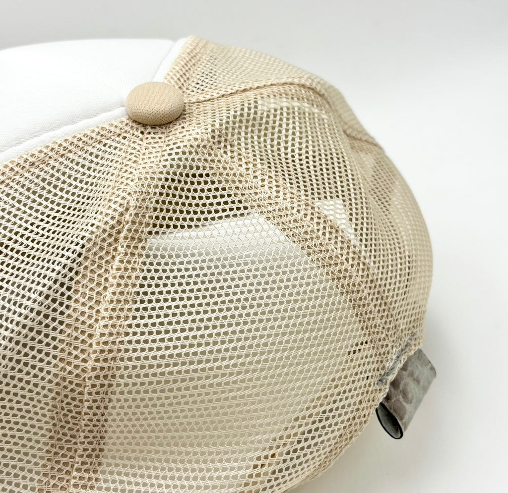 Close-up of tan mesh back panel and alligator leather tab on two-tone Frostytch trucker hat