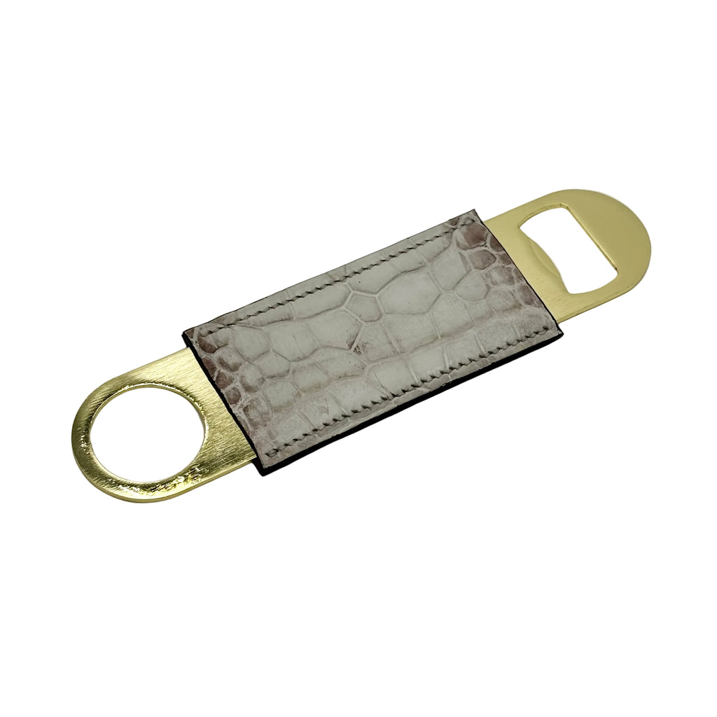 Himalayan alligator gold bottle opener angled view showing stone-grey alligator skin wrap and gold hardware ends