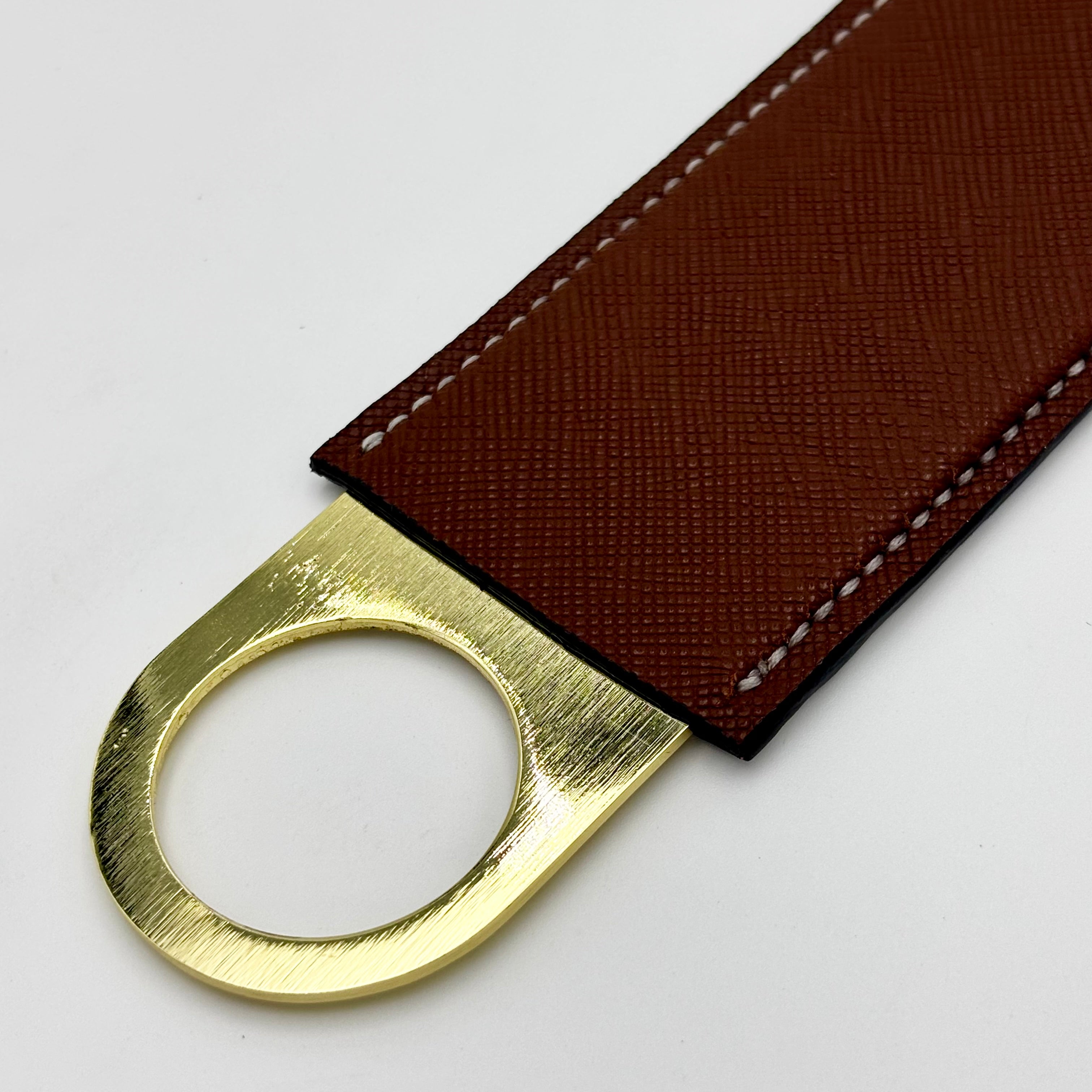 Close-up of Italian brown Saffiano leather lining and gold ring end of Himalayan alligator bottle opener